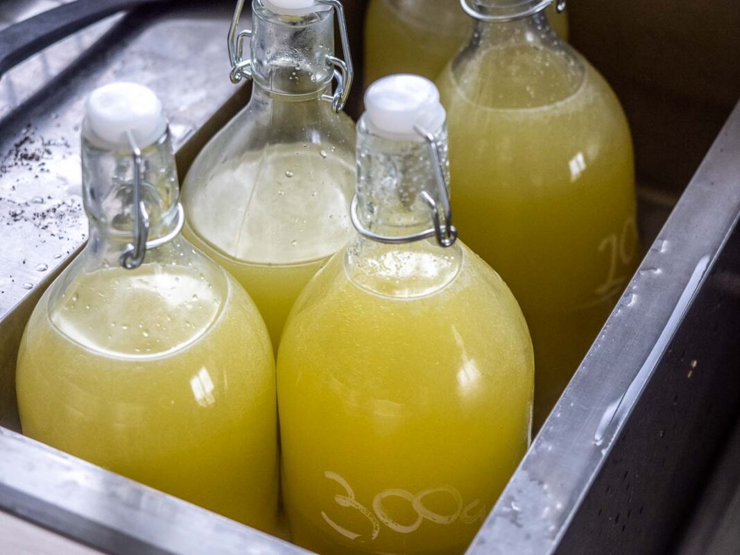 The Best Limoncello Recipe (We Tested 5 Versions!) 9 Image of DIY Distilling disolving sugar for limoncello in a water bath